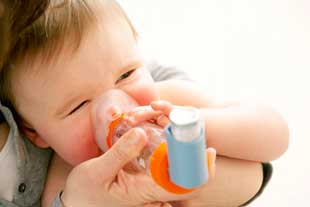 A baby using a spacer with an inhaler.